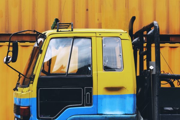 Yellow truck parked near a yellow container box